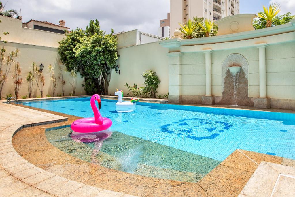 a swimming pool with a pink swan in the water at Meliá Campinas in Campinas