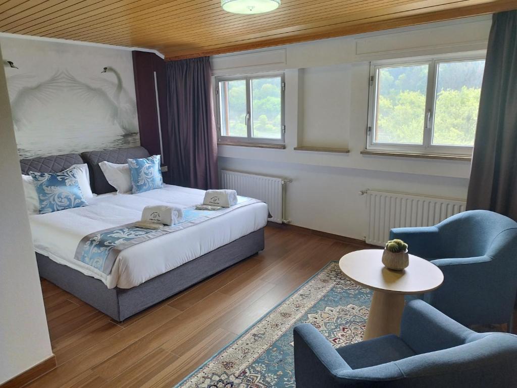 埃訥安的住宿－hotel whiteswan，一间卧室配有一张床、两把椅子和一张桌子