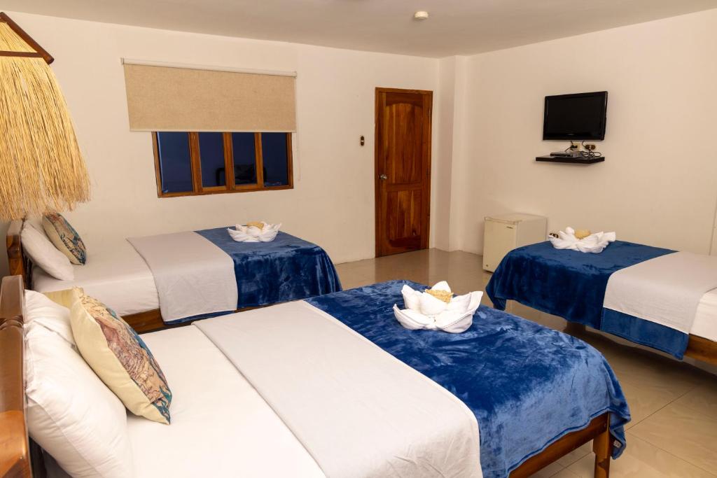 Postel nebo postele na pokoji v ubytování Galapagos Planet Hotel