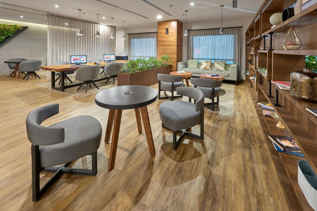 a lobby with tables and chairs and a couch at City Express Plus by Marriott Tijuana in Tijuana