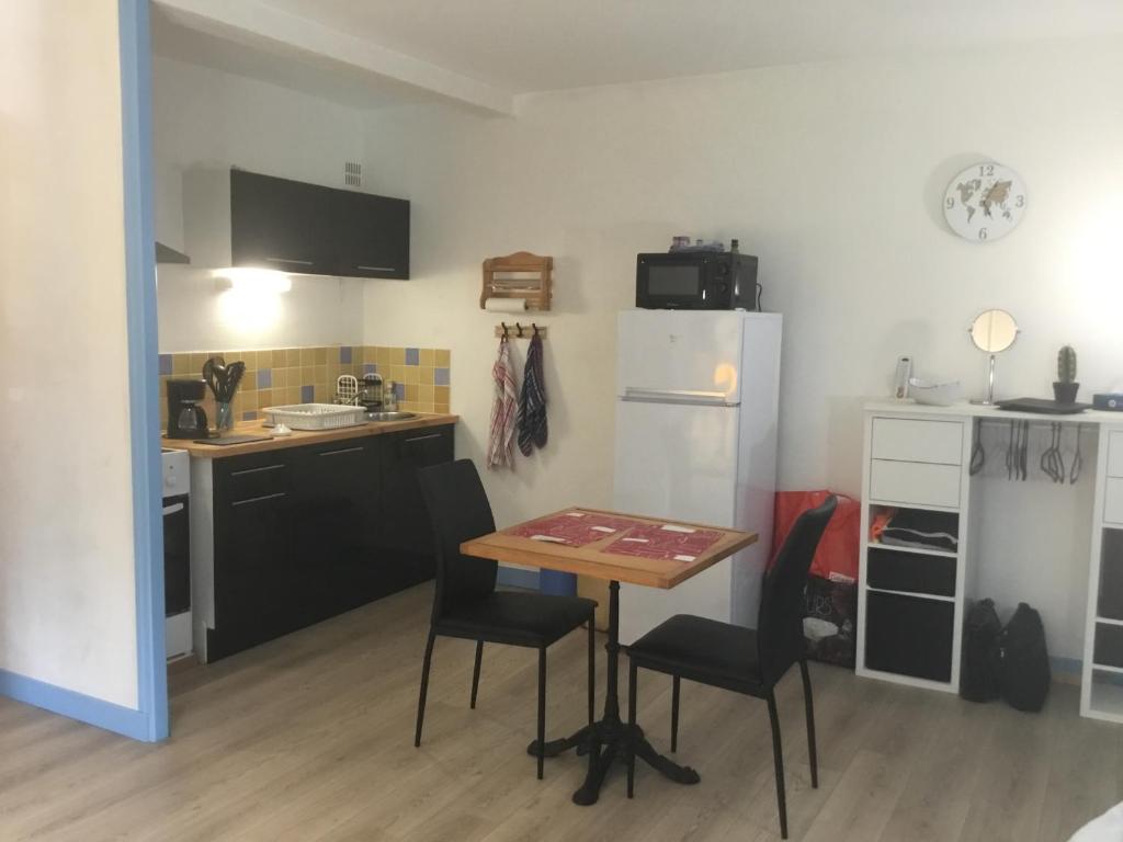 een keuken met een tafel en stoelen in een kamer bij Lo Cantalés d’Aubrac in Laguiole