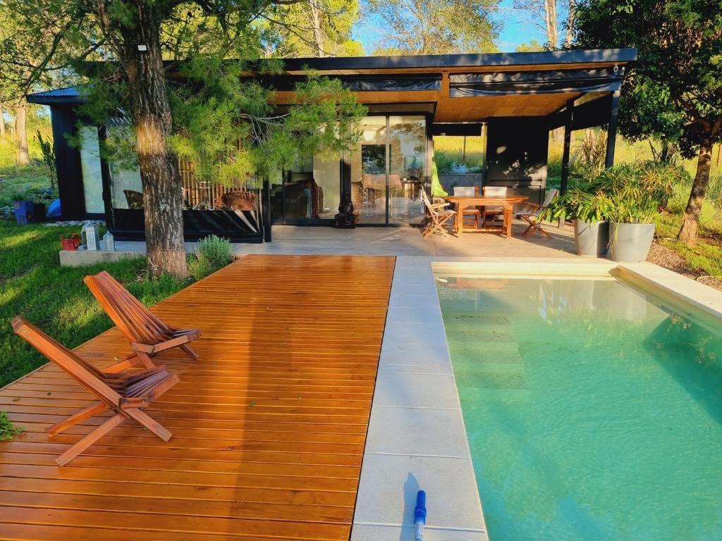 ein Haus mit einer Holzterrasse und einem Pool in der Unterkunft Colores de Manantiales in Villa General Belgrano