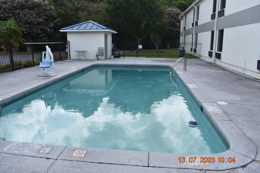 a swimming pool in front of a building at Executive Inn NEWLEY RENOVATED in Baker