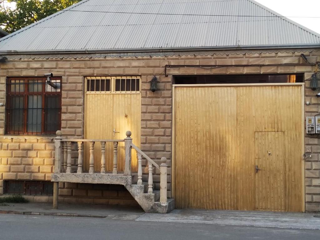 - un petit bâtiment en briques avec une porte et un escalier dans l'établissement Friends Guest House, à Gandja