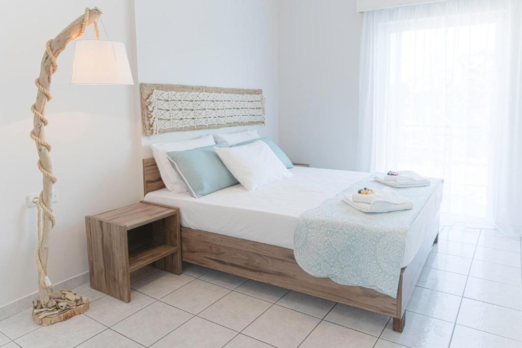 a white bedroom with a bed with a table at Mangata Apartment in Preveza