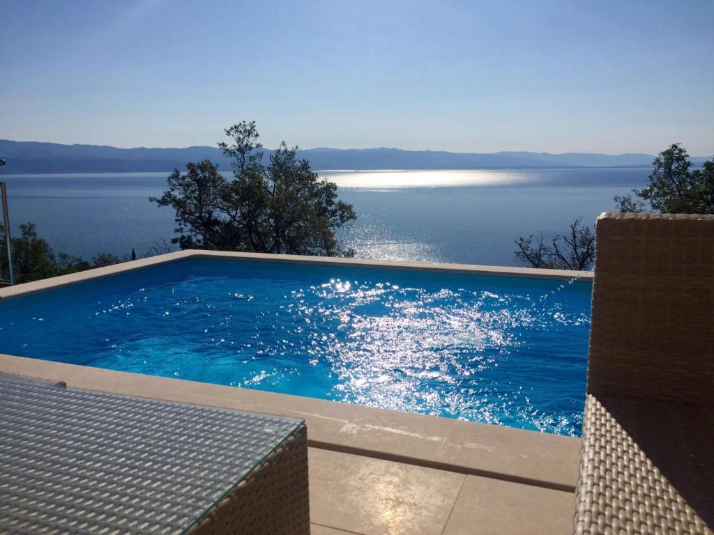 a swimming pool with a view of the water at Villa Sabine Apartment Losinj in Medveja