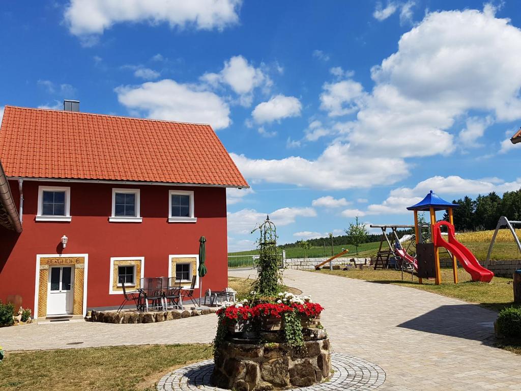 a red house with a playground and a slide at Ferienhäuser Schneeberger 