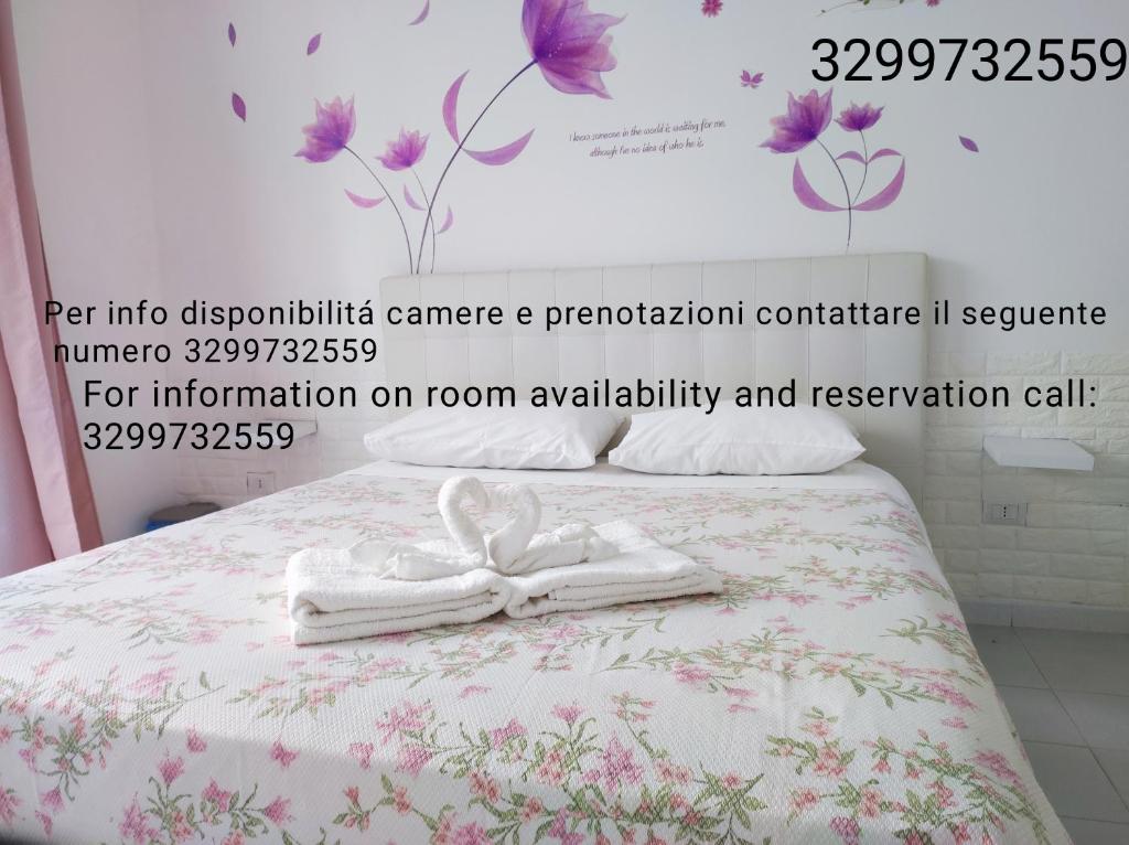 Un póster de una cama con dos toallas. en Le tre orchidee en Salerno