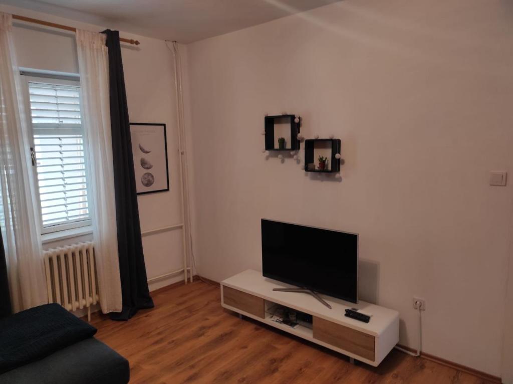 sala de estar con TV de pantalla plana en la pared en Apartmani Dominik, en Zadar