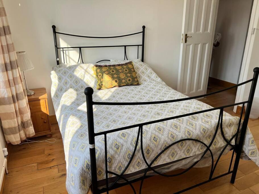 un letto con struttura nera e un cuscino sopra di Large whole house with 7 bedrooms in S.Norwood a Norwood