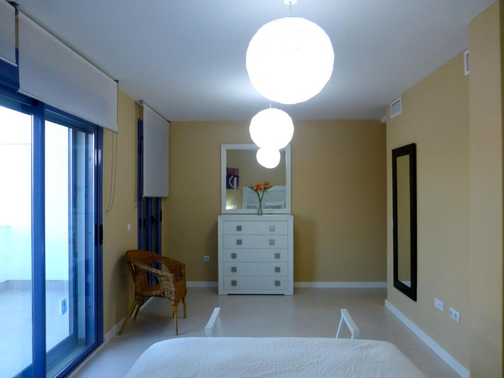 a bedroom with a bed and a dresser and two lights at Casa Valdevaqueros in Tarifa