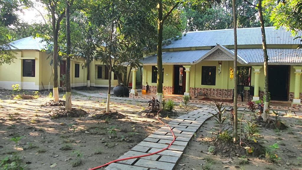 a yellow house with a red hose in front of it at A village home away from City in Ullāpāra