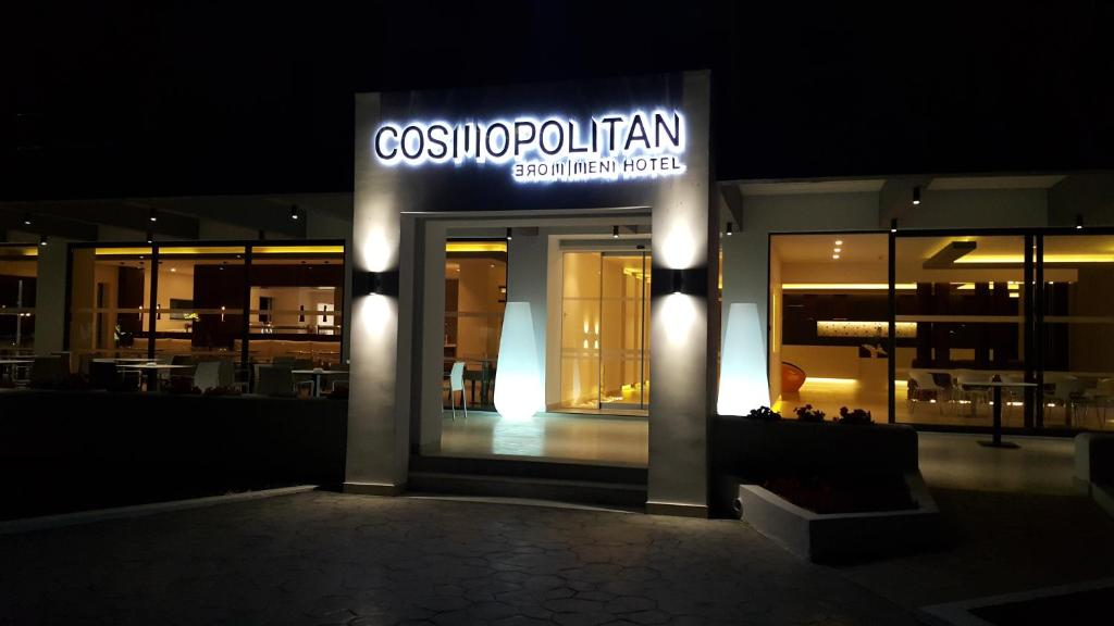 a building with a sign for a restaurant at night at Cosmopolitan Hotel in Kos Town