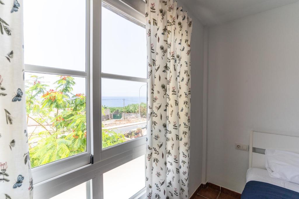a bedroom with a window with a view of the ocean at Oceanfront Rainbow Costa Adeje 14V35 in Callao Salvaje