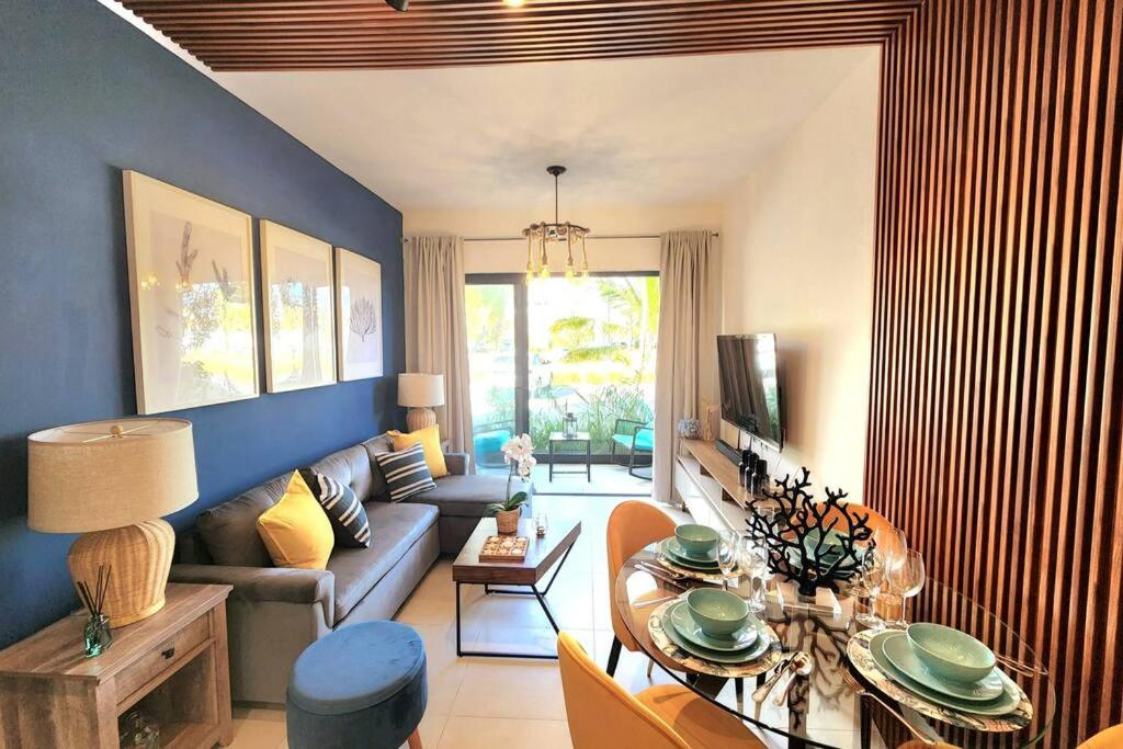 uma sala de estar com um sofá e uma mesa em Thematic beach apartment in CapCana area em Punta Cana