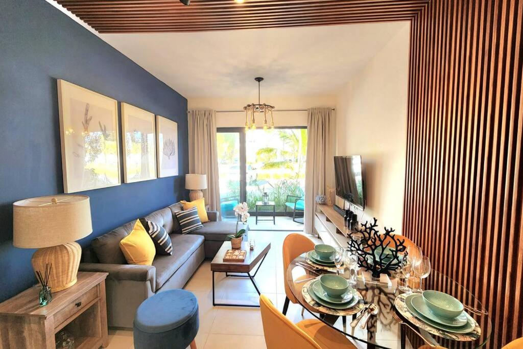 a living room with a couch and a table at Thematic beach apartment in CapCana area in Punta Cana