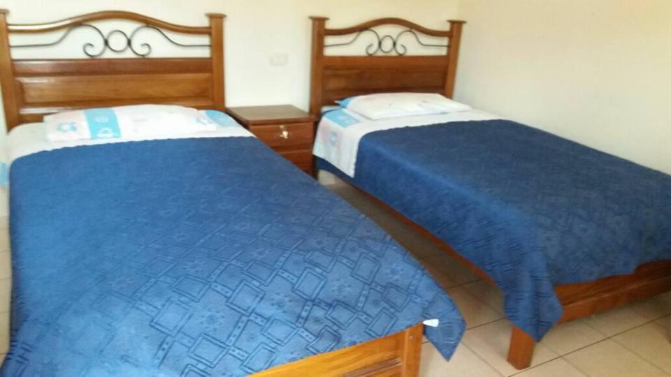 dos camas sentadas una al lado de la otra en una habitación en Residencial Teresita, en Vallegrande