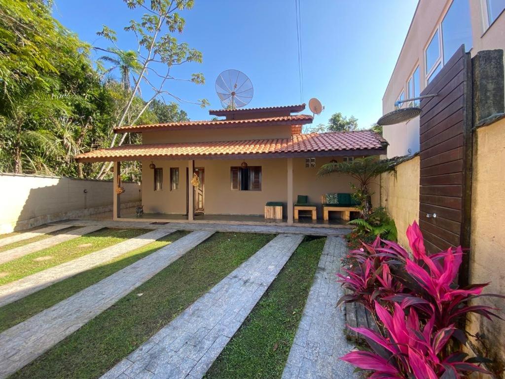 a small house with a patio in front of it at Linda casa Condomínio Costa do Sol - Bertioga in Bertioga