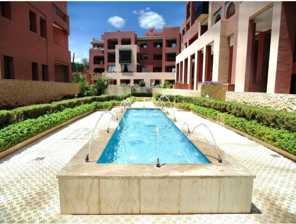Résidence Soltana, Marrakech في مراكش: مسبح وسط مبنى