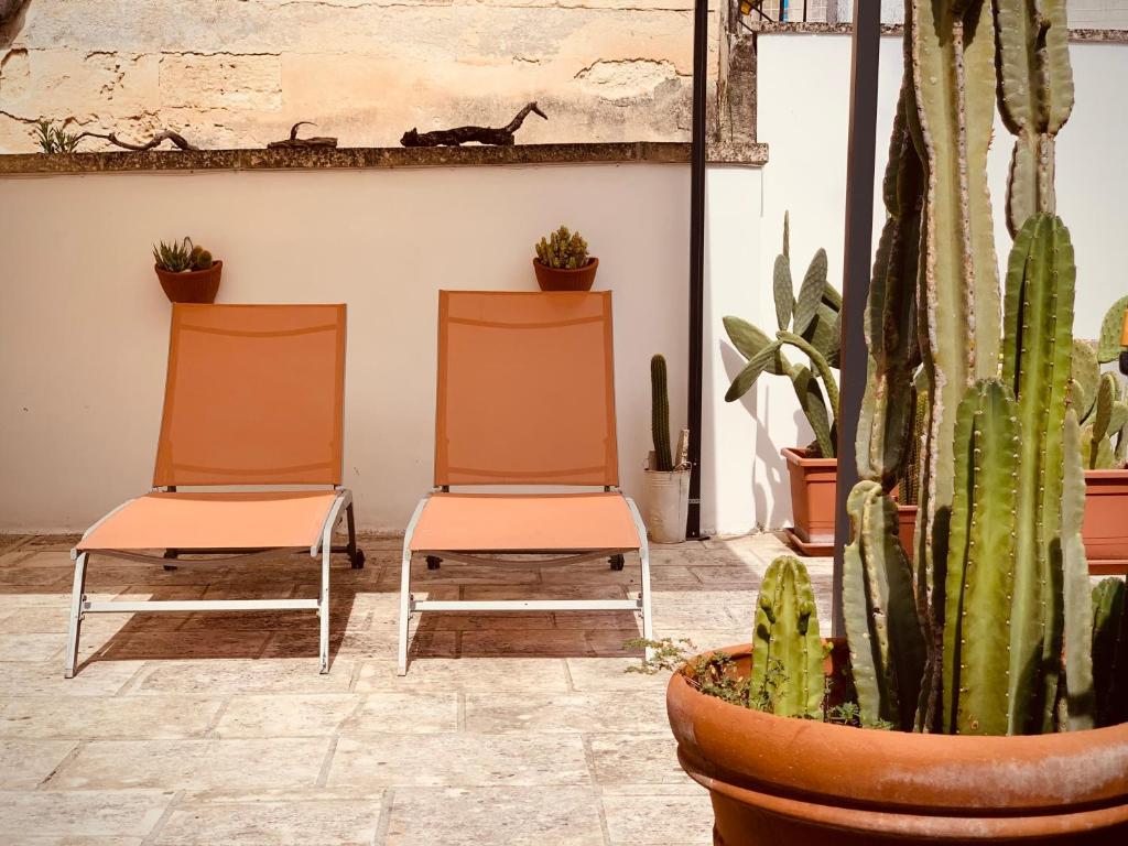 dwa pomarańczowe krzesła w pokoju z kaktusem w obiekcie Artas la tua casa indipendente a Lecce w mieście Lecce