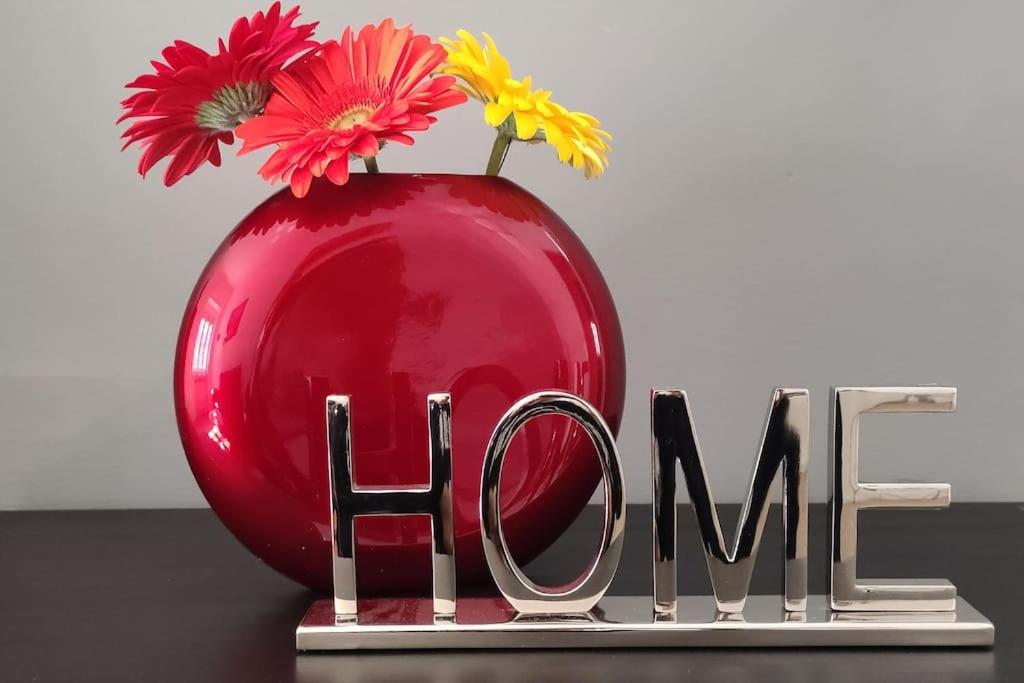 Un jarrón rojo con flores junto a la palabra amor en INTERNO NOVE - appartamento a Corsico en Corsico