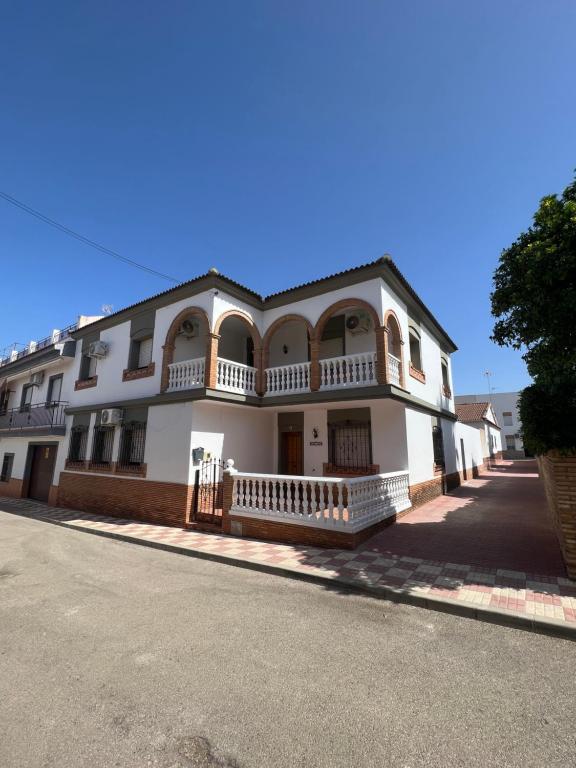 um grande edifício branco com uma varanda numa rua em casa grande en Córdoba, pueblo de la Victoria , 6 dormitorios em La Victoria