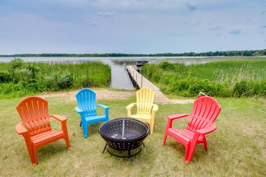 a group of four chairs and a fire pit next to a lake at Richville Vacation Rental with Fire Pit Near Trails in Ottertail