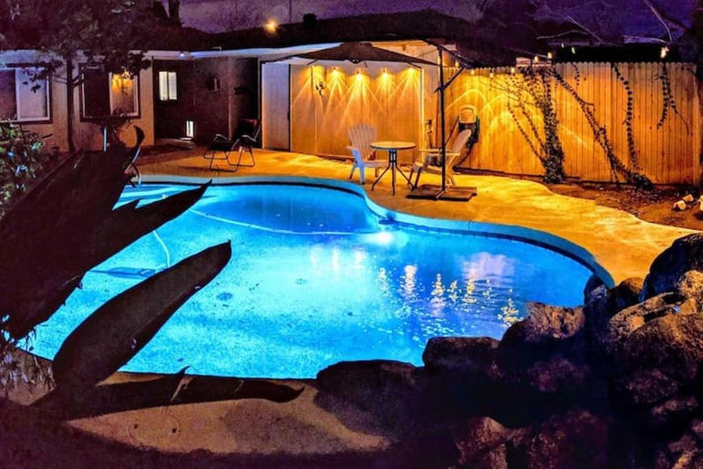 a swimming pool in a backyard at night at Loma Linda Courtyard Suites in Phoenix