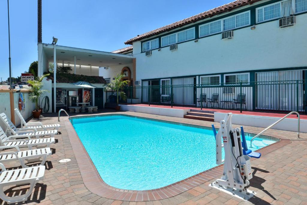 una piscina con sillas y un edificio en Americas Best Value Inn Loma Lodge, en San Diego