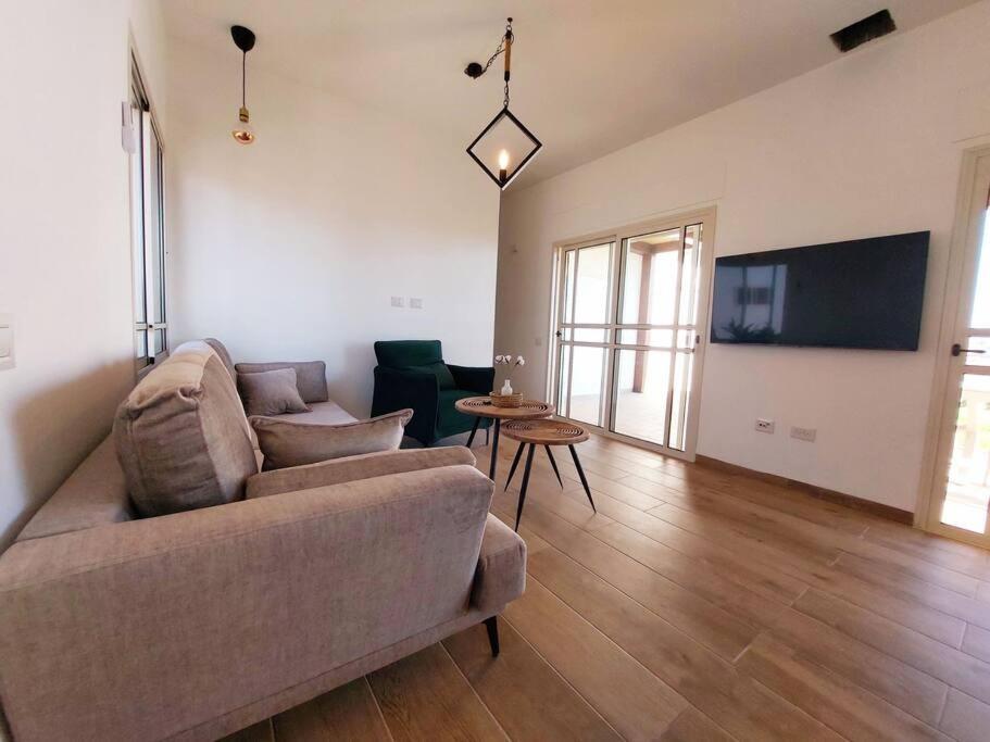 a living room with a couch and a table at בקצה in Ma'ale Gamla