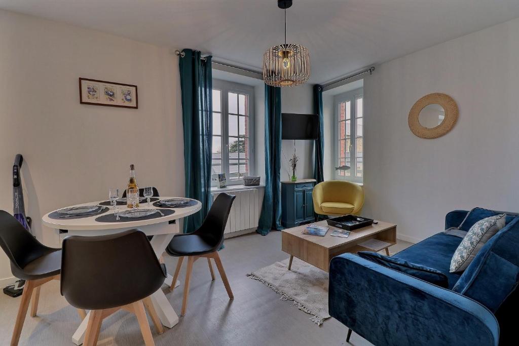 uma sala de estar com um sofá azul e uma mesa em Les Mots Bleus em Dinard