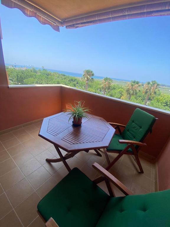 a balcony with a table and chairs and a window at Vistas al mar -Torre del mar- HOME RENT MALAGA in Vélez-Málaga