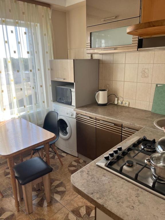 a kitchen with a stove and a table and a table and a table at saules street apartment in Ventspils