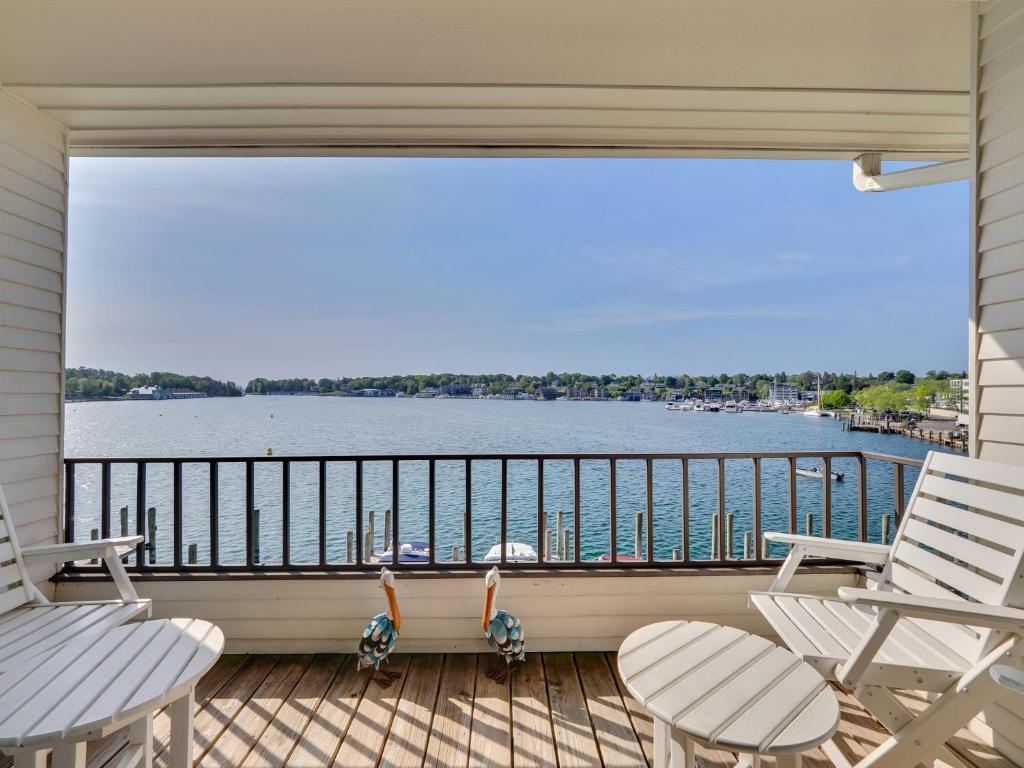a balcony with two chairs and a view of the water at 342 Edgewater Inn in Charlevoix