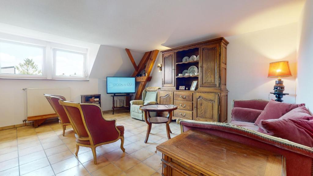 een woonkamer met een bank en een tafel bij Le Clos de Charlotte in Colmar