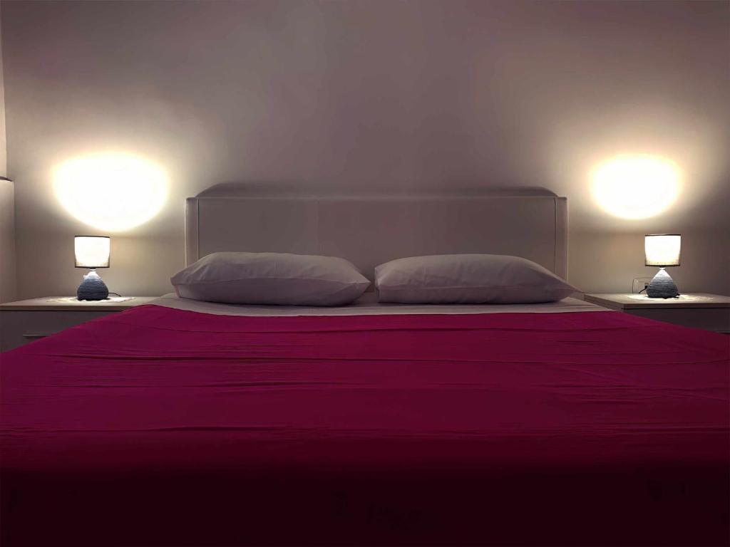 a bedroom with a large bed with two lamps at Marinella Casa Vacanze in Bacoli