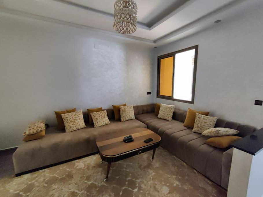 een woonkamer met een bank en een tafel bij Very Nice Relaxing Apartment In Agadir El Houda in Agadir