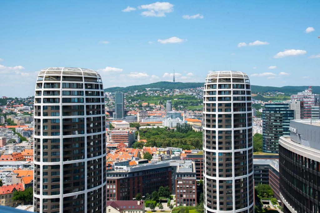 twee hoge wolkenkrabbers in een stad met gebouwen bij Luxury 1BDRM on the 28th floor in Bratislava