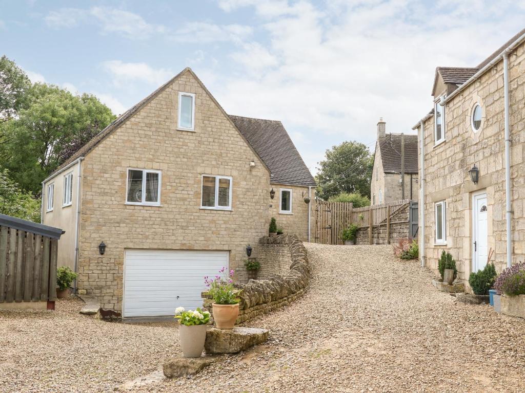 una casa de ladrillo con garaje en una entrada en Farm View Lodge, en Stroud