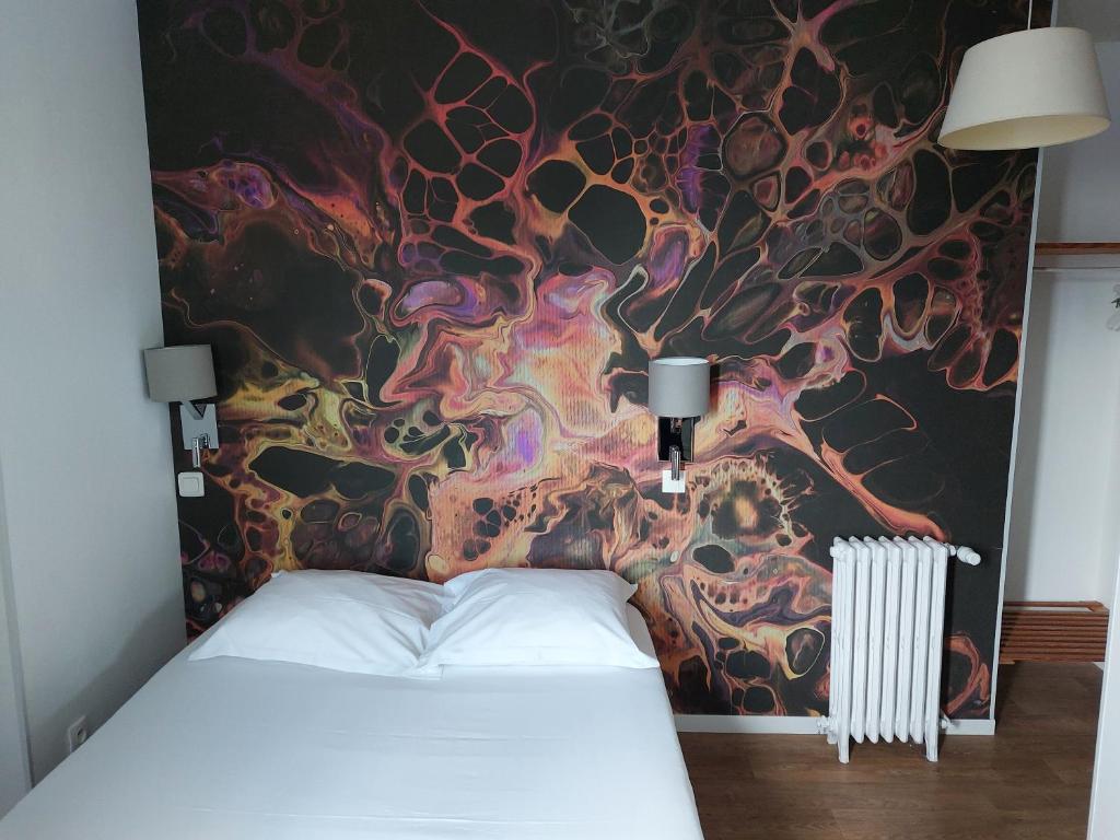 - une chambre avec un lit et un mur coloré dans l'établissement Le Royalty, à Angers