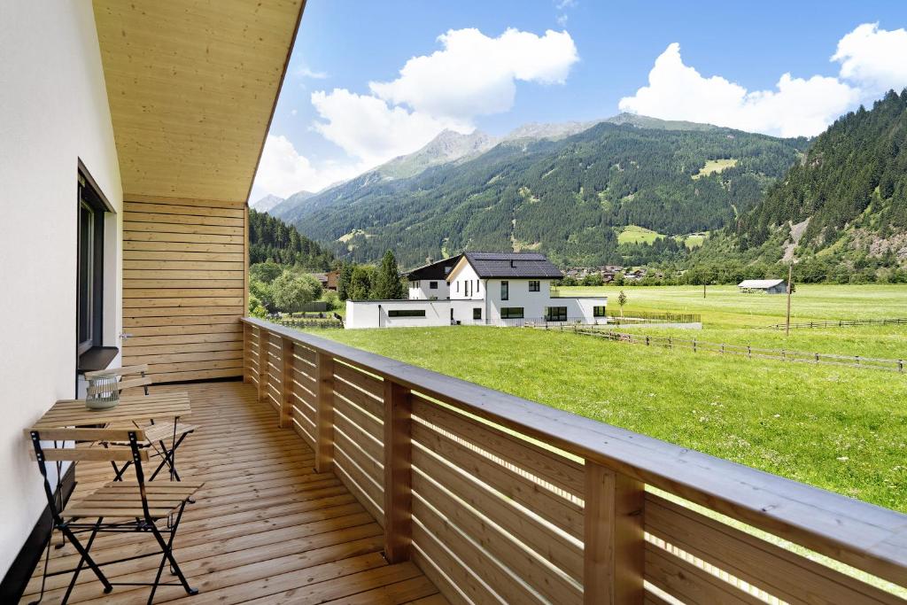 Un balcón con vista a un campo y montañas. en Stackler54 - mit Balkon, en Neustift im Stubaital