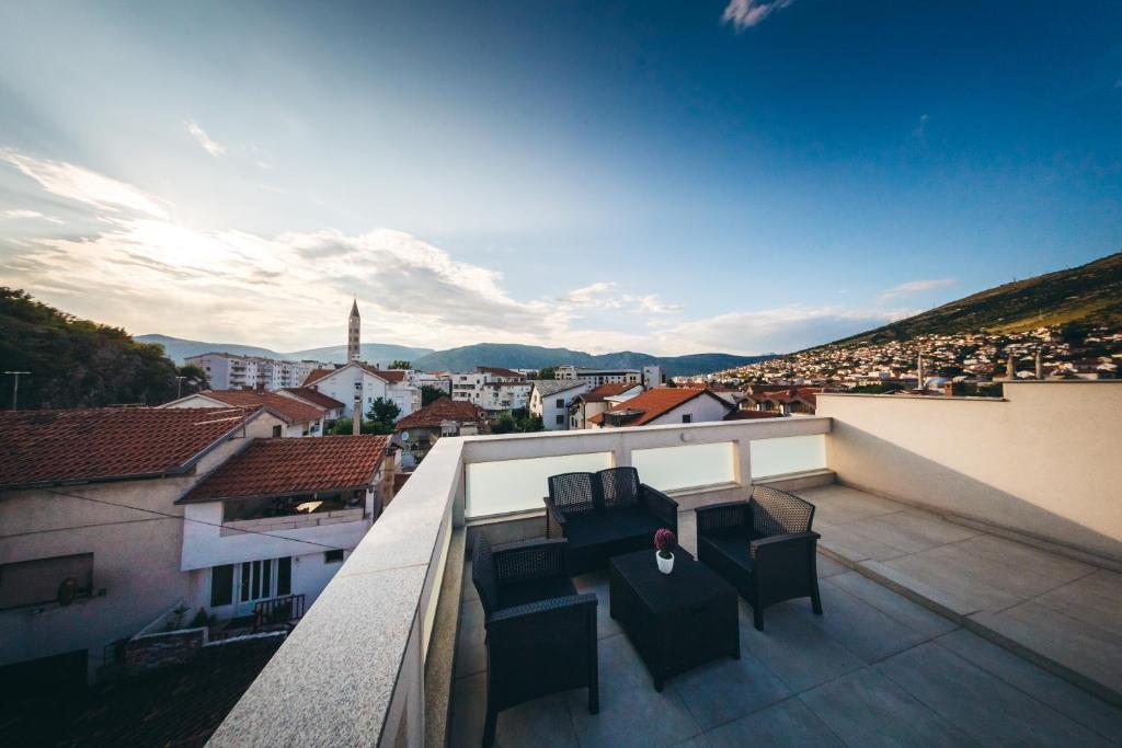 a balcony with two chairs and a view of a city at Elegant Studio Apartments Lasta in Mostar