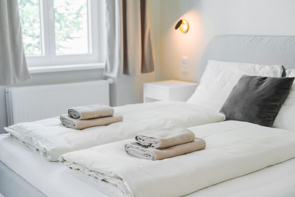 two white beds with towels on top of them at Premium apartment - walking distance to city center in Graz
