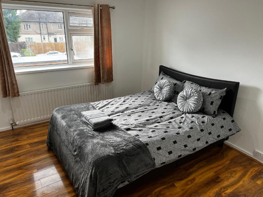 a bedroom with a bed with pillows and a window at Good priced double bed in Hayes in Northolt