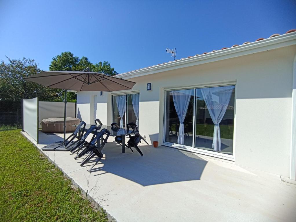 un groupe de chaises et un parasol sur une terrasse dans l'établissement Maison Jun, à Josse