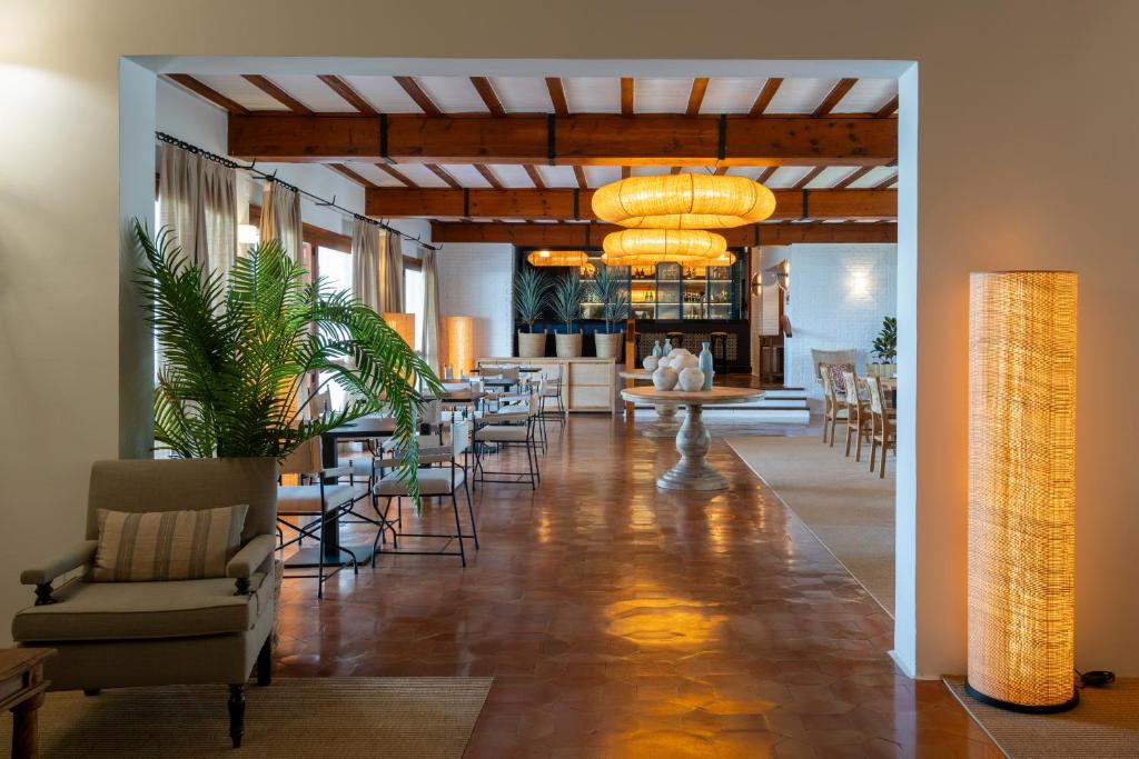 a dining room with tables and chairs and a lobby at Parador de Mazagón in Mazagón