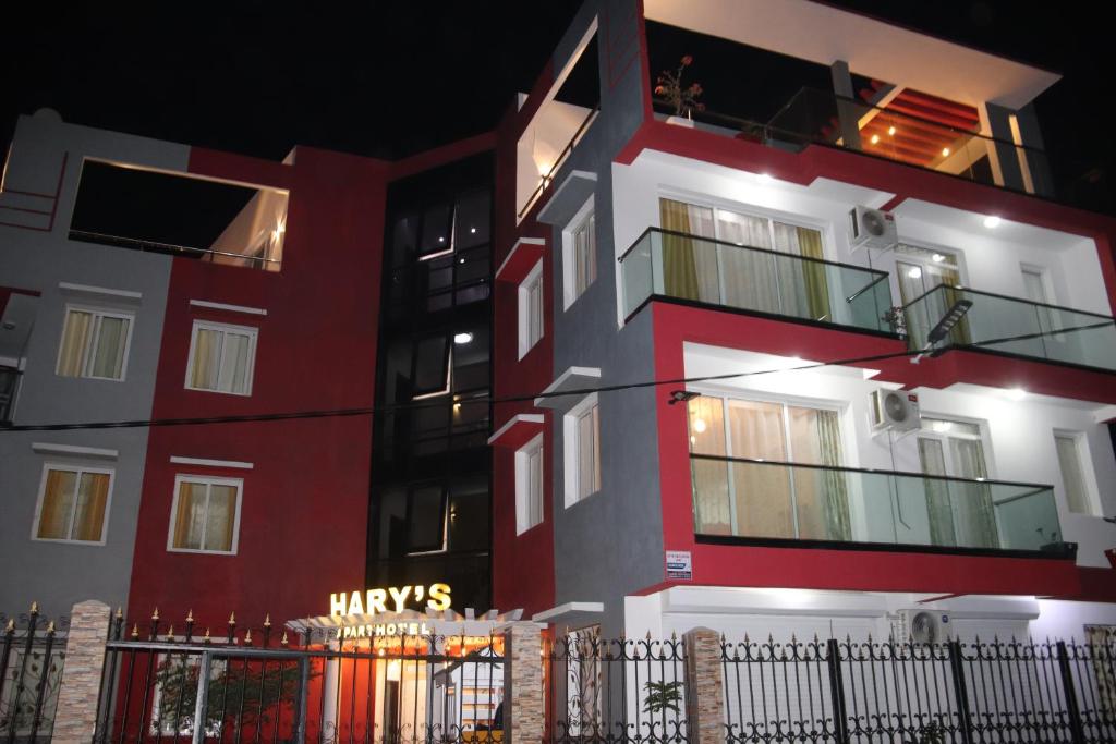 ein rot-weißes Gebäude mit einem Schild darauf in der Unterkunft Hary's Aparthotel in Toliara