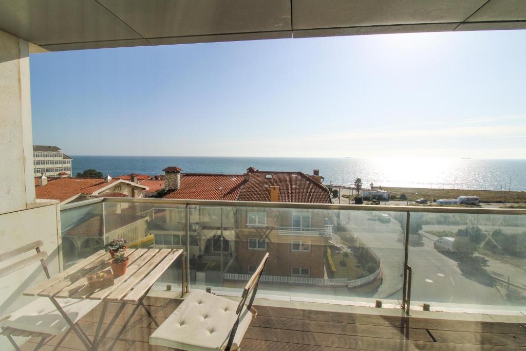 Un balcón con mesa y vista al mar. en Ocean View Luxury Apartment, en Vila Nova de Gaia
