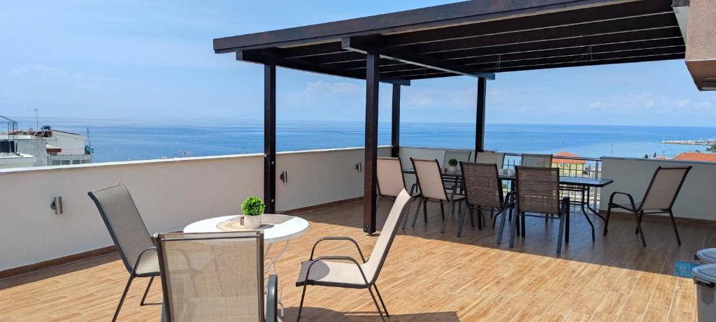 een balkon met een tafel en stoelen op een dak bij Sea Star Apartments Kallikratia in Nea Kalikratia