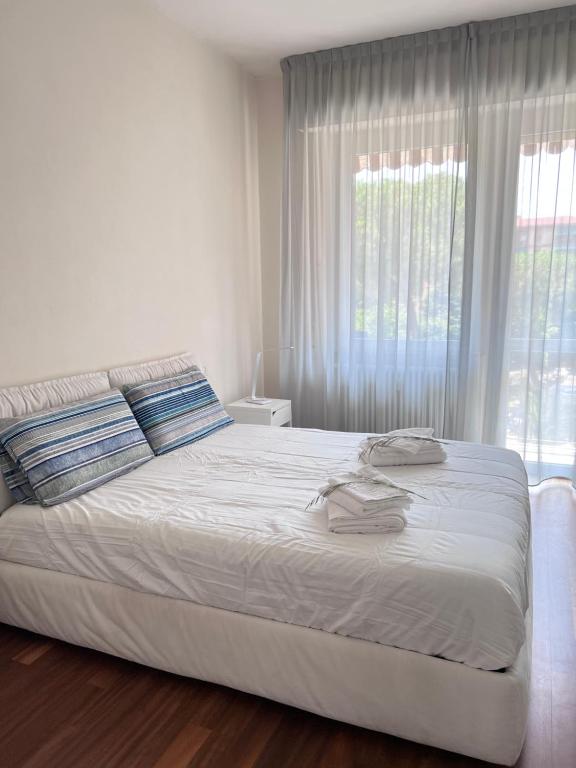een wit bed in een slaapkamer met een groot raam bij Stella house in La Spezia